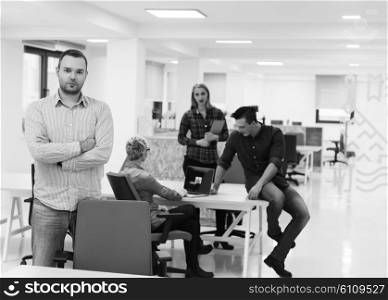 portrait of young business man in casual clothes sitting on table at new startup office space and working on tablet computer