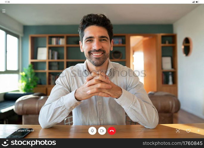 Portrait of young business man on a work video call while staying at home. Home office. New normal lifestyle.