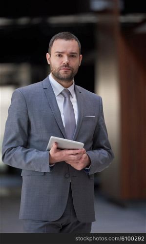 portrait of young business man with tablet computer at modern office