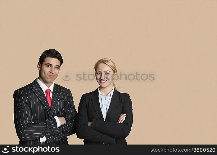 Portrait of young business team with arms crossed over colored background