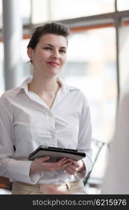 portrait of young business woman with tablet computer at modern office interior