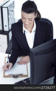 Portrait of young business woman working at her office over white background