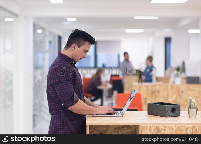 portrait of young businessman in casual clothes at modern startup business office space, working on laptop computer
