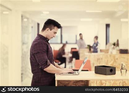portrait of young businessman in casual clothes at modern startup business office space, working on laptop computer