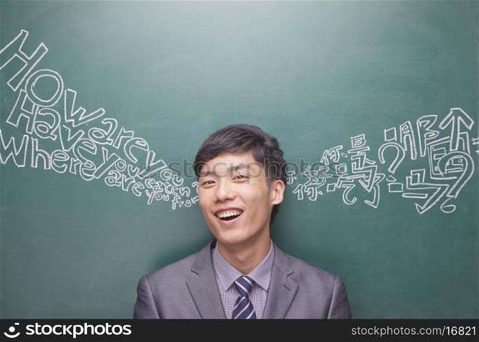 Portrait of young businessman in front of black board with Chinese and English script