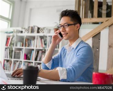 Portrait of young businessman in office holding his mobile. Portrait of young businessman with mobile