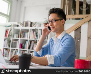 Portrait of young businessman in office holding his mobile. Portrait of young businessman with mobile