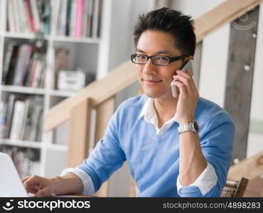 Portrait of young businessman in office holding his mobile. Portrait of young businessman with mobile