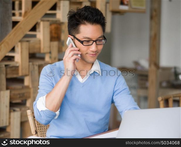 Portrait of young businessman in office holding his mobile. Portrait of young businessman with mobile
