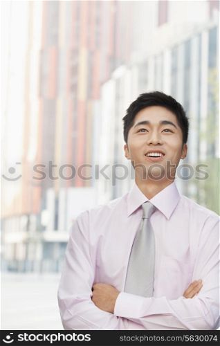 Portrait of young businessman, looking up