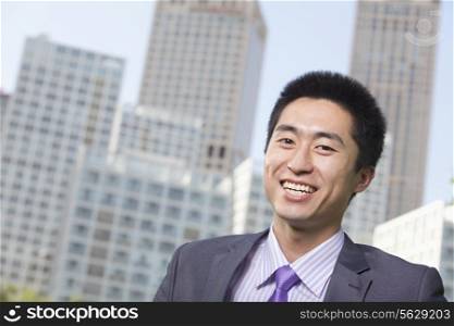 Portrait of young businessman outside in the business district, Beijing