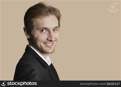 Portrait of young businessman smiling over colored background