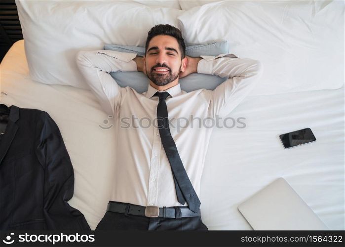 Portrait of young businessman taking a break from work and relaxing after a hard day at the hotel room. Business travel concept.