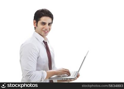 Portrait of young businessman using laptop on white background