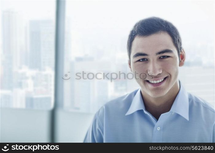 Portrait of young businessman with cityscape behind him