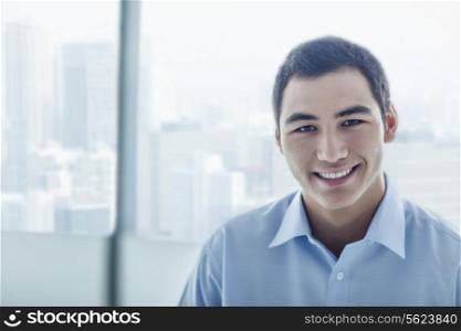 Portrait of young businessman with cityscape behind him