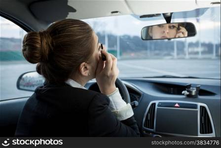 Portrait of young businesswoman applying mascara in car
