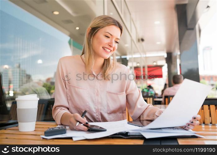 Portrait of young businesswoman checking paperwork and working at coffee shop.coffee shop. Business concept.