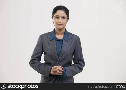 Portrait of young businesswoman in suit isolated over gray background