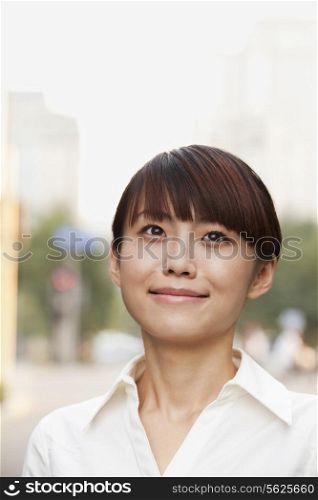 Portrait of young businesswoman laughing outside in Beijing