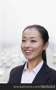 Portrait of Young Businesswoman Looking at Camera with Traffic Below