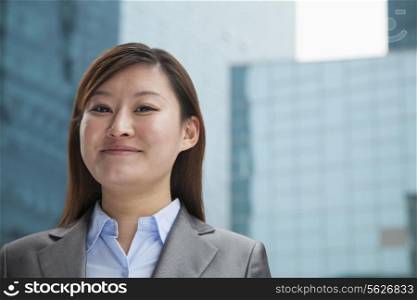 Portrait of young businesswoman outdoors among skyscrapers