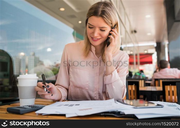 Portrait of young businesswoman talking on the phone while working at coffee shop.coffee shop. Business concept.