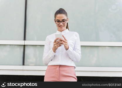 Portrait of young businesswoman using mobile phone on a break at outdoor