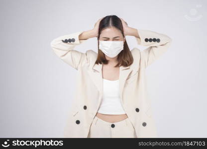 portrait of young businesswoman wearing a surgical mask over white background studio