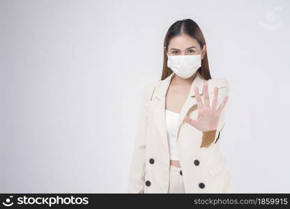 portrait of young businesswoman wearing a surgical mask over white background studio