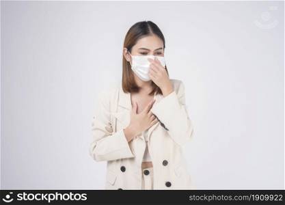 portrait of young businesswoman wearing a surgical mask over white background studio