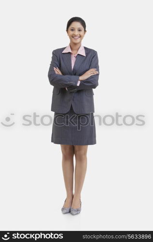 Portrait of young businesswoman with arms crossed isolated over white background