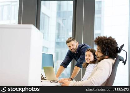 Portrait of young businesswoman with male colleagues working in office