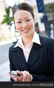Portrait of young businesswoman with mobile and bluetooth