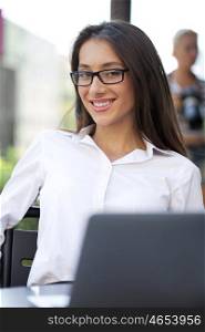 Portrait of young businesswoman working on a laptop