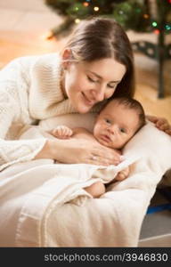 Portrait of young caring mother with newborn baby lying in basket