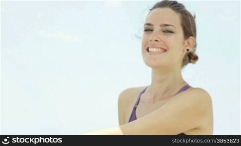 Portrait of young caucasian woman looking at camera near the sea. Head and shoulders, copy space