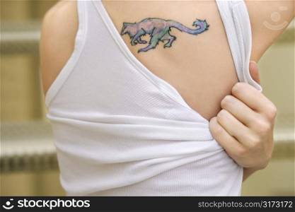 Portrait of young Caucasian woman with tattoo on shoulder.