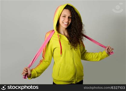 Portrait of young cheerful smiling woman in sports wear on urban background