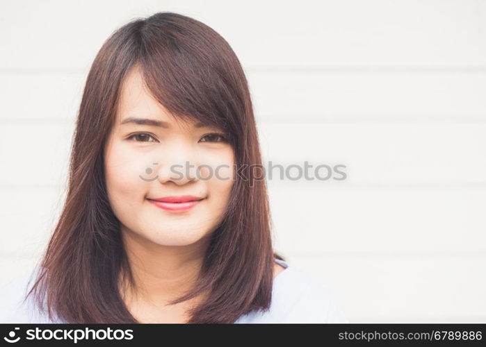 Portrait of young cheerful smiling woman, over concrete wall
