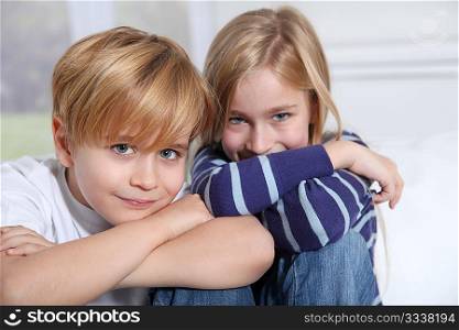 Portrait of young children sitting in sofa at home