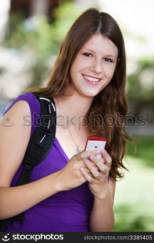 Portrait of young college girl holding cell phone