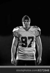 portrait of young confident American football player on field at night