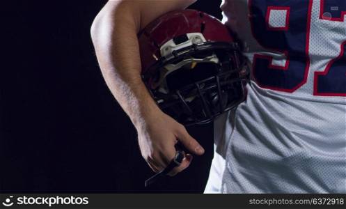 portrait of young confident American football player on field at night