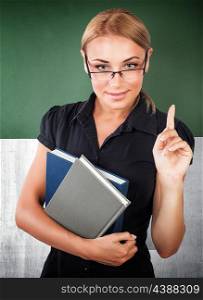 Portrait of young confident business woman wearing glasses and holding in hands books, explaining something, is holding a conference in the office