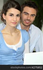 portrait of young couple beside laptop