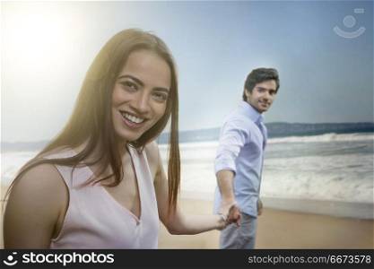 Portrait of young couple holding hand in hand on beach