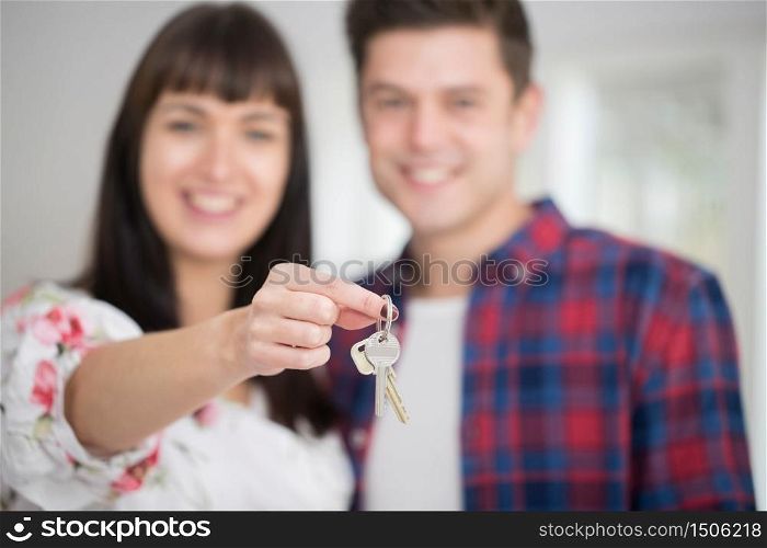 Portrait Of Young Couple Holding Keys To New Home