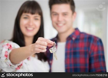 Portrait Of Young Couple Holding Keys To New Home