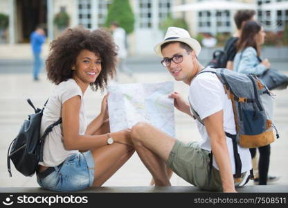 Portrait of young couple holding map